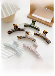 Dettaglio delle pinze per capelli in acetato in sei colori con motivi a tartaruga e marmo