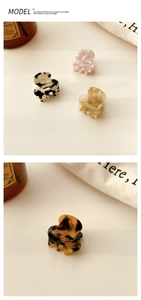Detail view of mini acetate hair claws in marble, shell, and tortoiseshell patterns