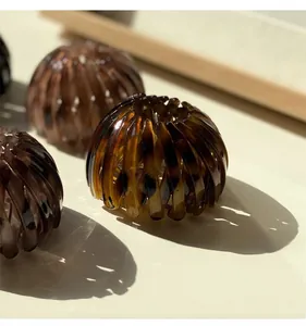 Detailed view of the expandable amber resin bird nest hair clip with a glossy finish