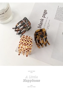 Three acetate hair claws with tortoiseshell, leopard, and checkerboard patterns