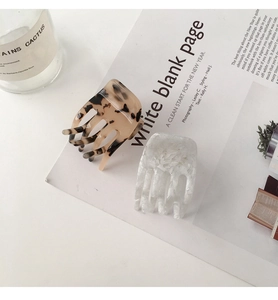 Detail view of acetate claw clips with tortoiseshell and marble patterns on a magazine