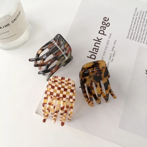 Three acetate hair claws in marble, tortoiseshell and checkerboard patterns set