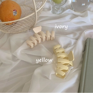 Minimalist matte wavy hair claw clips in ivory and yellow on elegant satin fabric