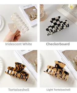 Four patterns of acetate hair claws including checkered and tortoiseshell on a white book