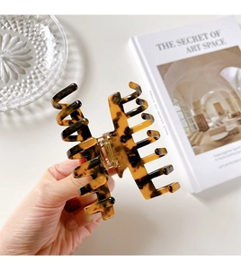 Macro shot of tortoise shell pattern hair claw clip with strong metal spring mechanism