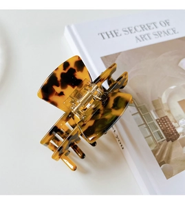 Close-up of tortoise shell pattern acetate hair claw clip with golden metal spring