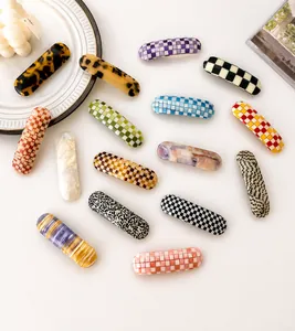 Close-up of assorted tortoiseshell and checkered hair clips in various pastel colors
