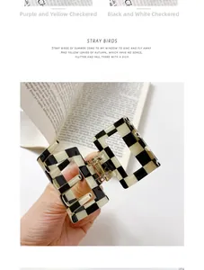 Close-up of square hollow hair claw clip with black and white checkerboard pattern