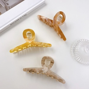 Three acrylic hair clips in amber and marble tones for elegant women's hairstyles