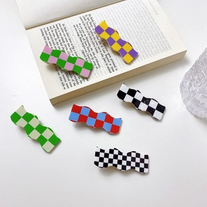 Checkerboard pattern wavy hair claws in multiple colors on a white table background
