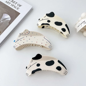 Detailed view of three cute acetate dog hair claws with artistic polka dot patterns
