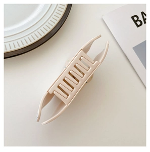 Detail view of cream acetate hair claw clip with internal teeth and matte finish