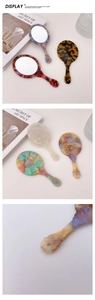 Detail view of retro acetate handheld mirrors in tortoiseshell and marble patterns