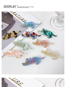Close-up of cute cat hair clips with colorful acrylic patterns and gold details