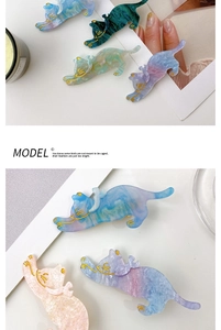 Detail of cute marble acetate cat hair clips with elegant gold-lined facial features