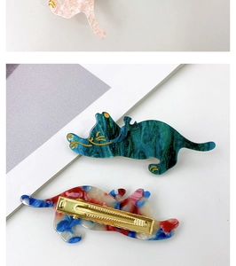 Detailed view of cat-shaped acetate hair clips with golden metal alligator clip structure