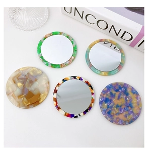 Flat lay of five round marble patterns acetate makeup mirrors with shell textures