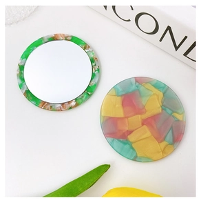 Detail view of round acetate makeup mirrors with marble texture and geometric pattern