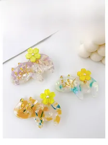 Détail de pinces à cheveux chat en acétate de 6 cm avec texture marbre et fleurs