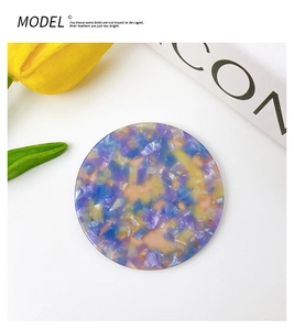 Detailed view of round tortoiseshell pattern acetate mirror with floral purple and blue textures