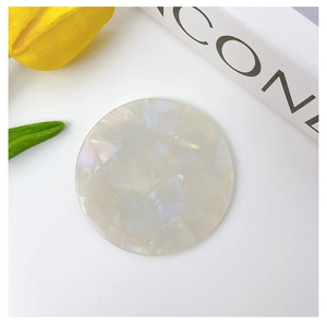 Close-up of a round acetate mirror with pearlescent finish and shell texture detail