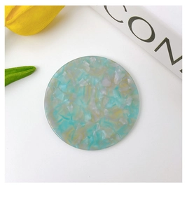 Detailed top view of a round acetate pocket mirror with mint green marble texture
