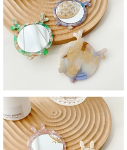 Detail of round acetate portable mirrors with animal ears and marble texture patterns