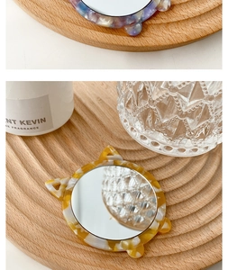 Detail of portable cat-eared makeup mirror with tortoiseshell marble texture frame