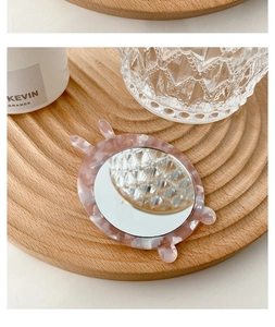 Detail of pink marble pattern portable vanity mirror with cute rabbit ears on wood tray