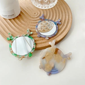 Three cute animal-shaped acetate mini makeup mirrors with marble textures on wooden stands