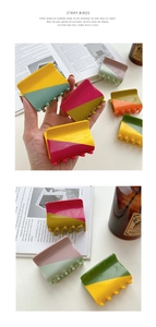 Detail of a square acetate hair claw clip featuring a two-tone diagonal splicing design