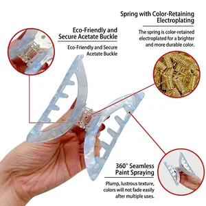 Elegant pale blue acetate claw clip with gold-plated spring shown in detail and hand-held