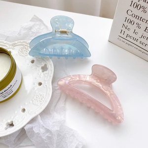 Elegant semi-circular acetate shark hair clips in light blue and iridescent pink finishes