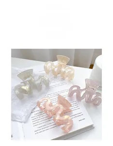 Détail de pinces à cheveux en acétate coloré aux tons pastel sur fond minimaliste