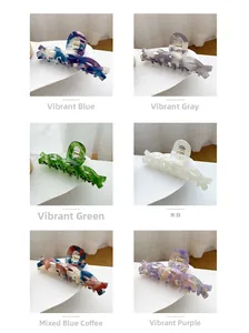 Detailed view of large acetate hair claws in six vibrant marbled colors with gold springs