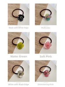 Plusieurs couleurs d'élastiques à cheveux fleur de rose en acétate présentés en grille