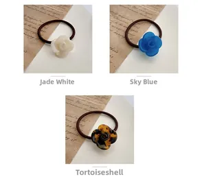 Détails d'élastiques à cheveux roses en acétate coloris ivoire, bleu aqua et écaille de tortue