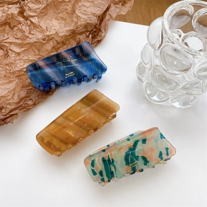 Three-piece acetate claw clip set with gold France lettering in blue, amber, and marble