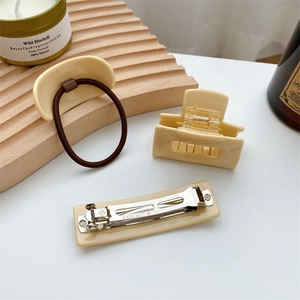 Three-piece cream acetate hair accessory set including a claw clip, hair tie and barrette