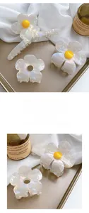 Detailed view of French vintage acetate flower hair claws with pearlescent white finish