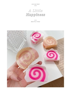 Detail shot of cute Narutomaki style hair claw clips with pink and white spiral texture