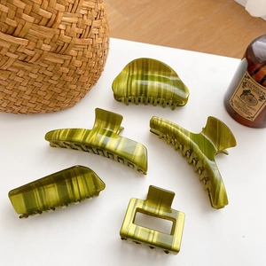 Five-piece green marble acetate hair claw set with various geometric shapes on white surface