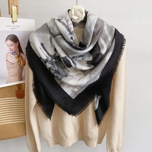 Detail of artistic horse print square shawl with soft fringe on a cream knit sweater