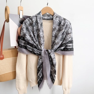 Elegant thistle pattern thistle pattern scarf with fringe details on beige knitwear background