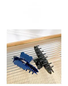 Detail of dark blue marble-patterned bear claw clip and sleek black rectangular hair clip