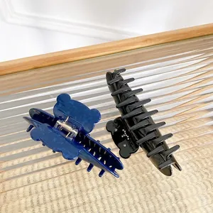 Blue teddy bear hair claw and black shark clip set on an elegant glass tray