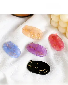 Detailed view of colorful cat-shaped hair clips in resin with gold feline line art