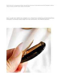 Detail view of a 4cm black acetate cat-shaped hair clip with golden metal spring teeth