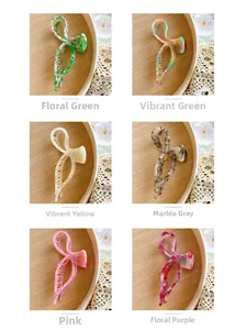 Detail view of 6 colorful acetate bow hair claws with elegant marble and floral patterns