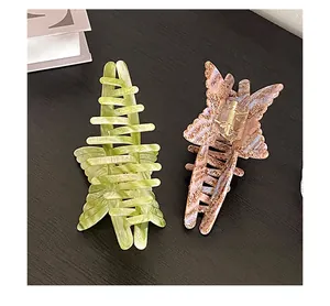 Detail view of two acetate butterfly hair claws in marble green and leopard print patterns